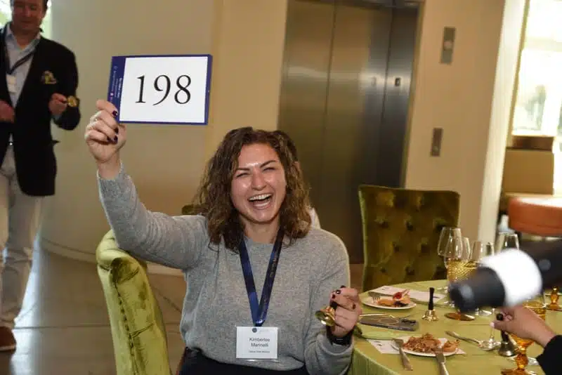 festival of the bells recap bidding woman holding up bidding number